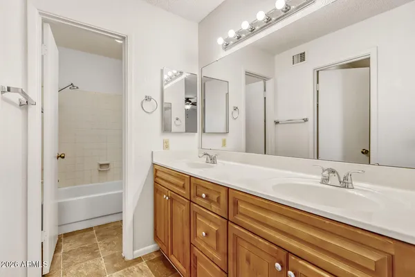 a bathroom with a sink double vanity granite tub and shower