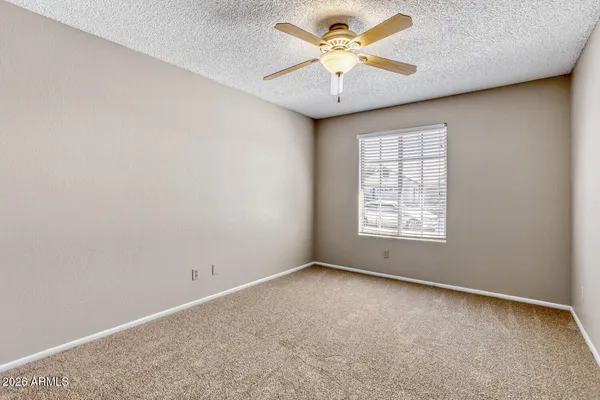 an empty room with a window and a fan