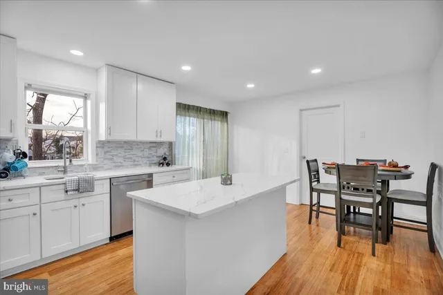 a large white kitchen with a table and chairs