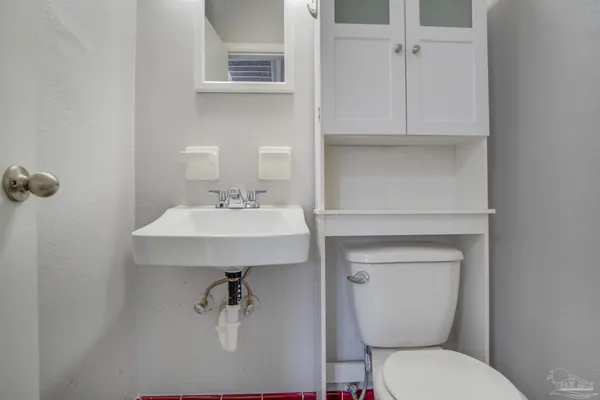 a bathroom with a toilet sink and mirror