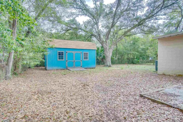 a view of a house with a yard and large tree