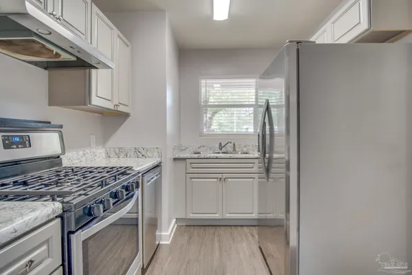 a kitchen with stainless steel appliances granite countertop a stove and a sink