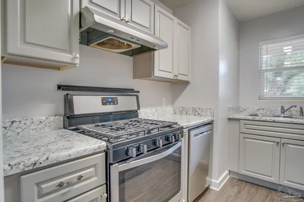 a kitchen with stainless steel appliances granite countertop a stove and a sink