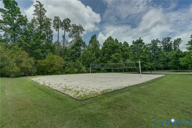 a view of a white house in a big yard with big trees