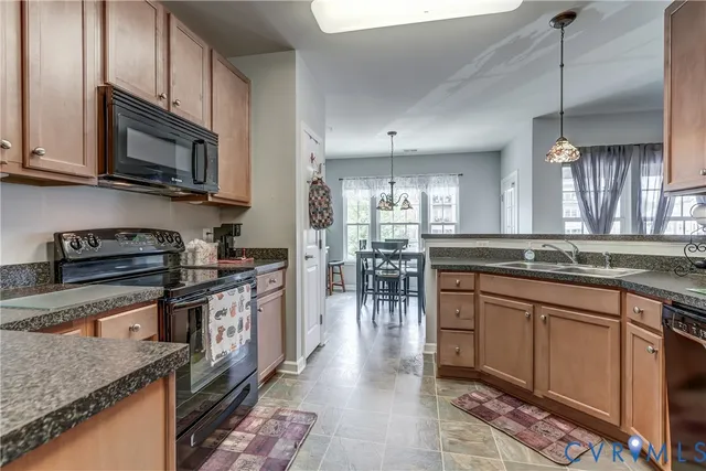 a kitchen with stainless steel appliances granite countertop a sink a stove and a granite counter tops
