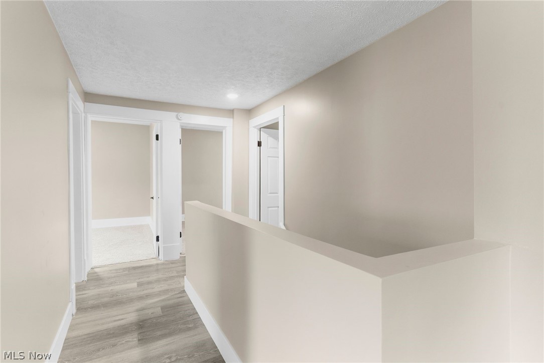 4646 Kirk Road Youngstown, OH 44515 - Photo 17 of 18 Corridor with a textured ceiling and light wood-type flooring