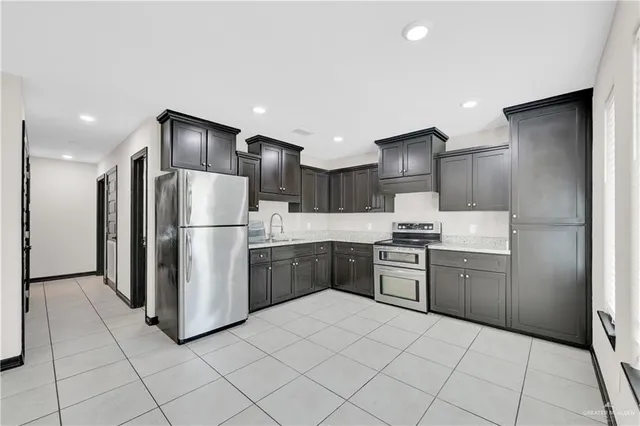 a kitchen with granite countertop a refrigerator and a sink