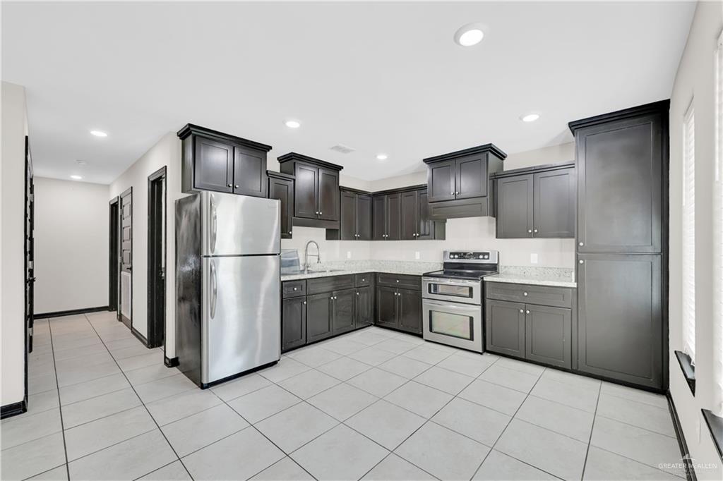 606 North Inspiration Road, Unit 6 Alton, TX 78573 - Photo 2 of 14 a kitchen with granite countertop a refrigerator and a sink