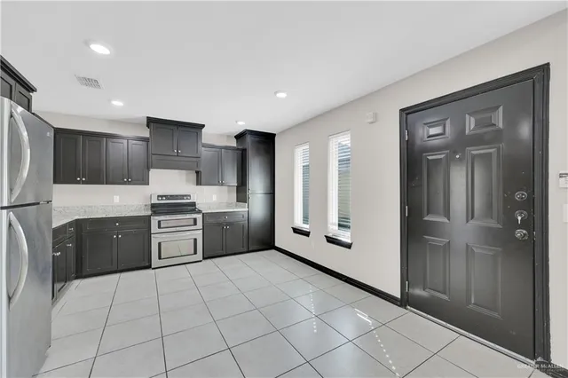 a kitchen with stainless steel appliances a refrigerator and a stove top oven