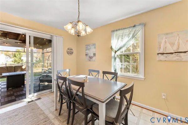 a view of a dining room with furniture a chandelier and wooden floor
