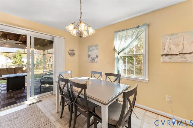 a view of a dining room with furniture a chandelier and wooden floor