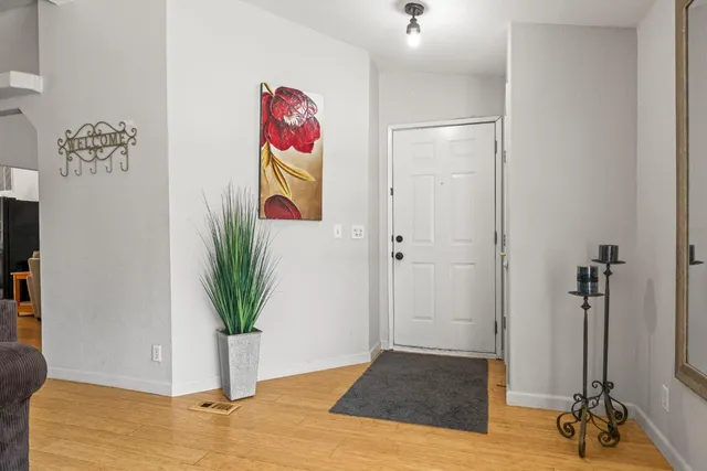 a view of a hallway with wooden floor and a potted plant