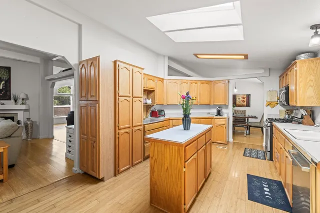 a kitchen with stainless steel appliances granite countertop a refrigerator a sink and a stove