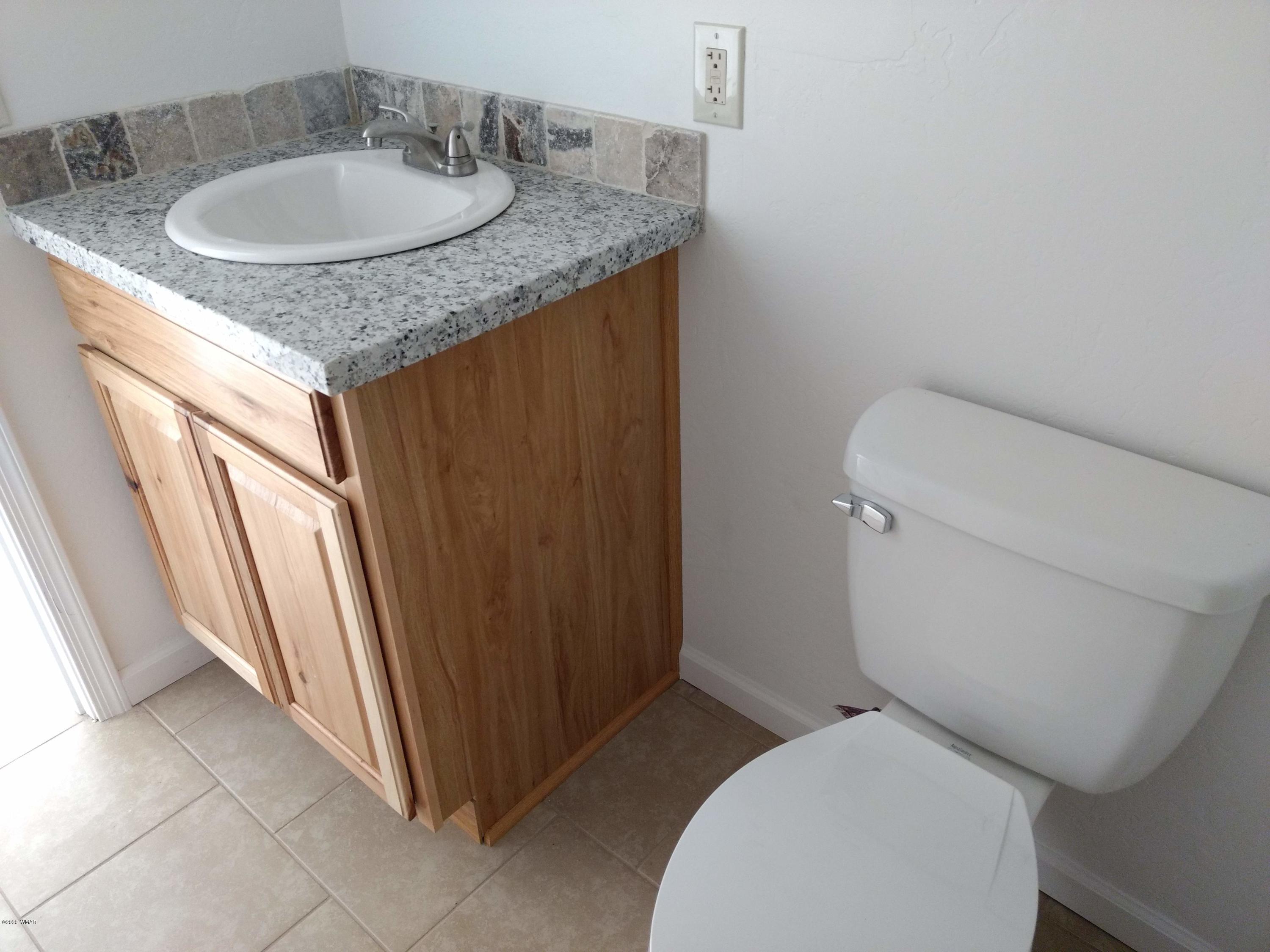 9 County Road Show Low, AZ 85901 - Photo 13 of 46 a bathroom with a granite countertop toilet sink and mirror