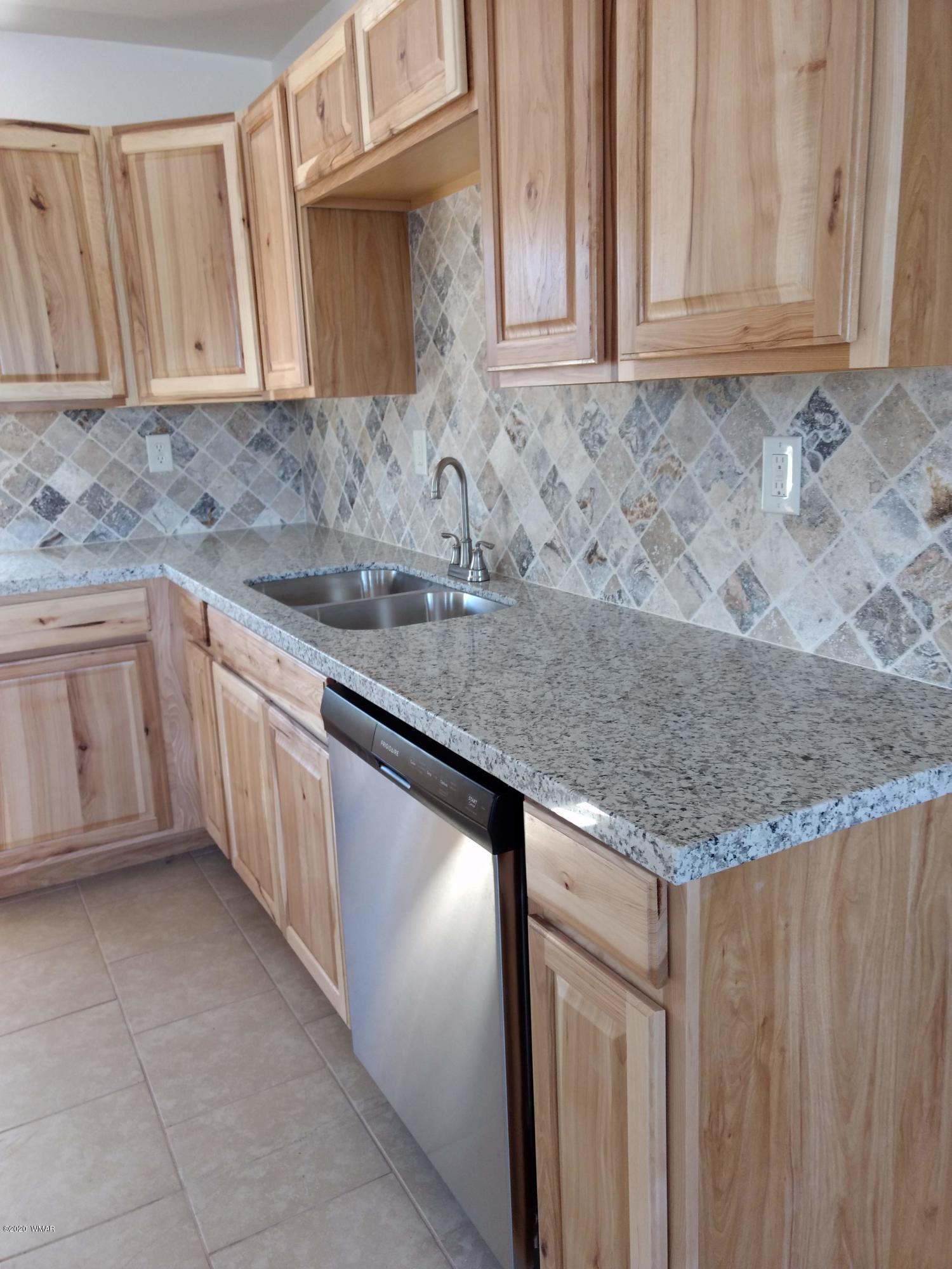 9 County Road Show Low, AZ 85901 - Photo 10 of 46 a kitchen with granite countertop a sink dishwasher stove and cabinets