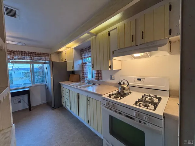 a kitchen with a sink stove and cabinets