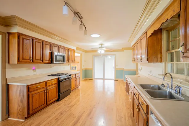 a kitchen with stainless steel appliances granite countertop a sink and wooden cabinets