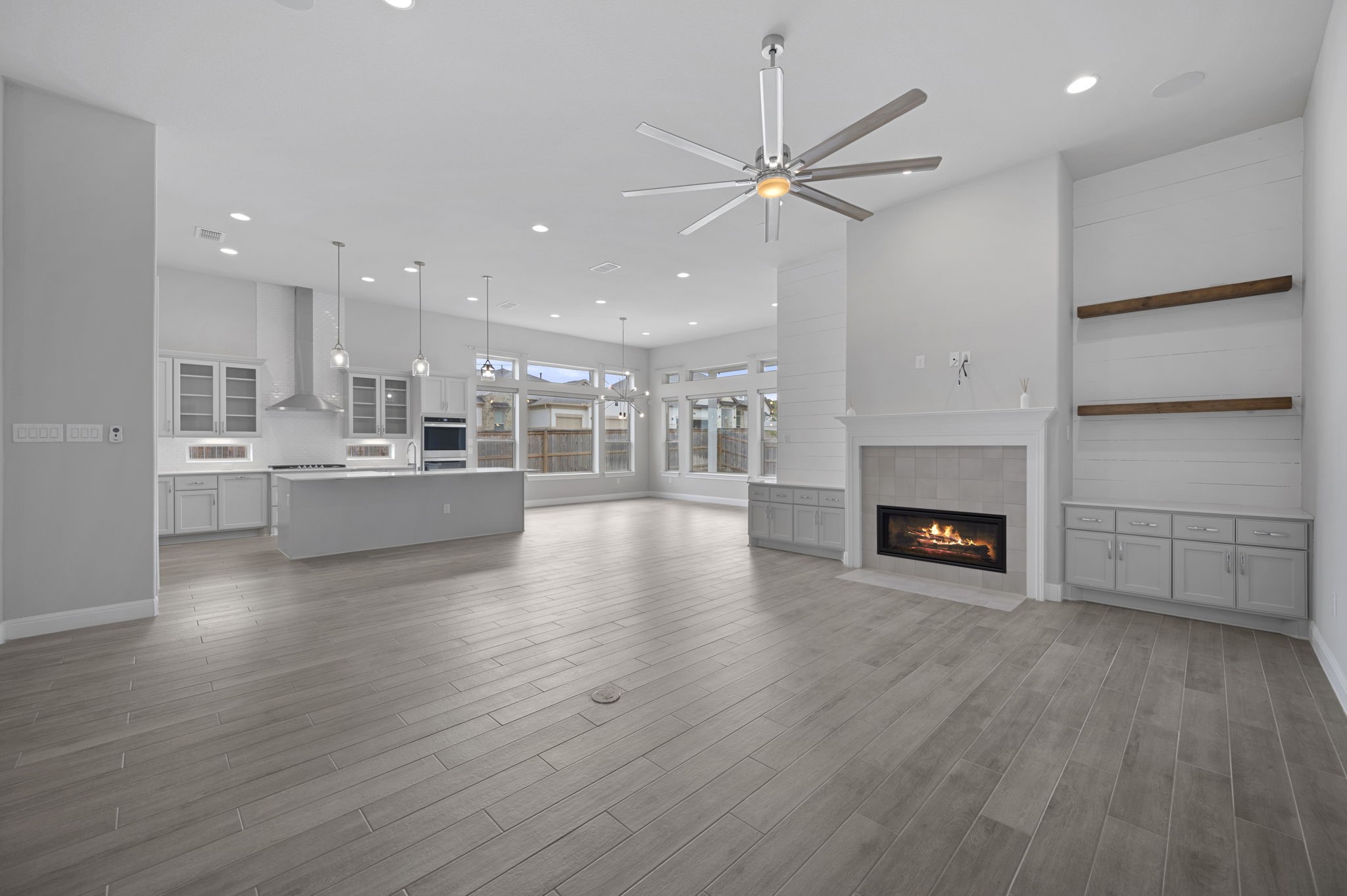 165 Eclipse Drive Austin, TX 78737 - Photo 11 of 38 an empty room with wooden floor fireplace and windows