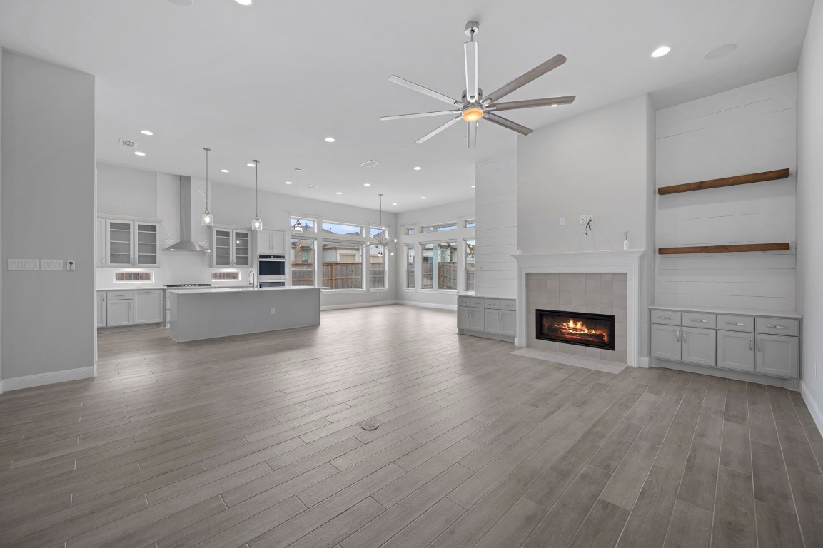 165 Eclipse Drive Austin, TX 78737 - Photo 11 of 38 an empty room with wooden floor fireplace and windows
