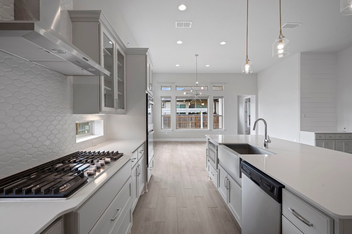 165 Eclipse Drive Austin, TX 78737 - Photo 15 of 38 a kitchen with kitchen island a counter space a sink a stove and wooden floor