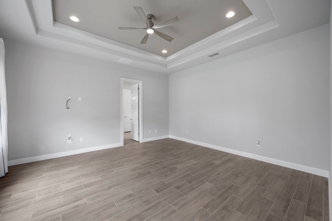 165 Eclipse Drive Austin, TX 78737 - Photo 21 of 38 an empty room with wooden floor and ceiling fan
