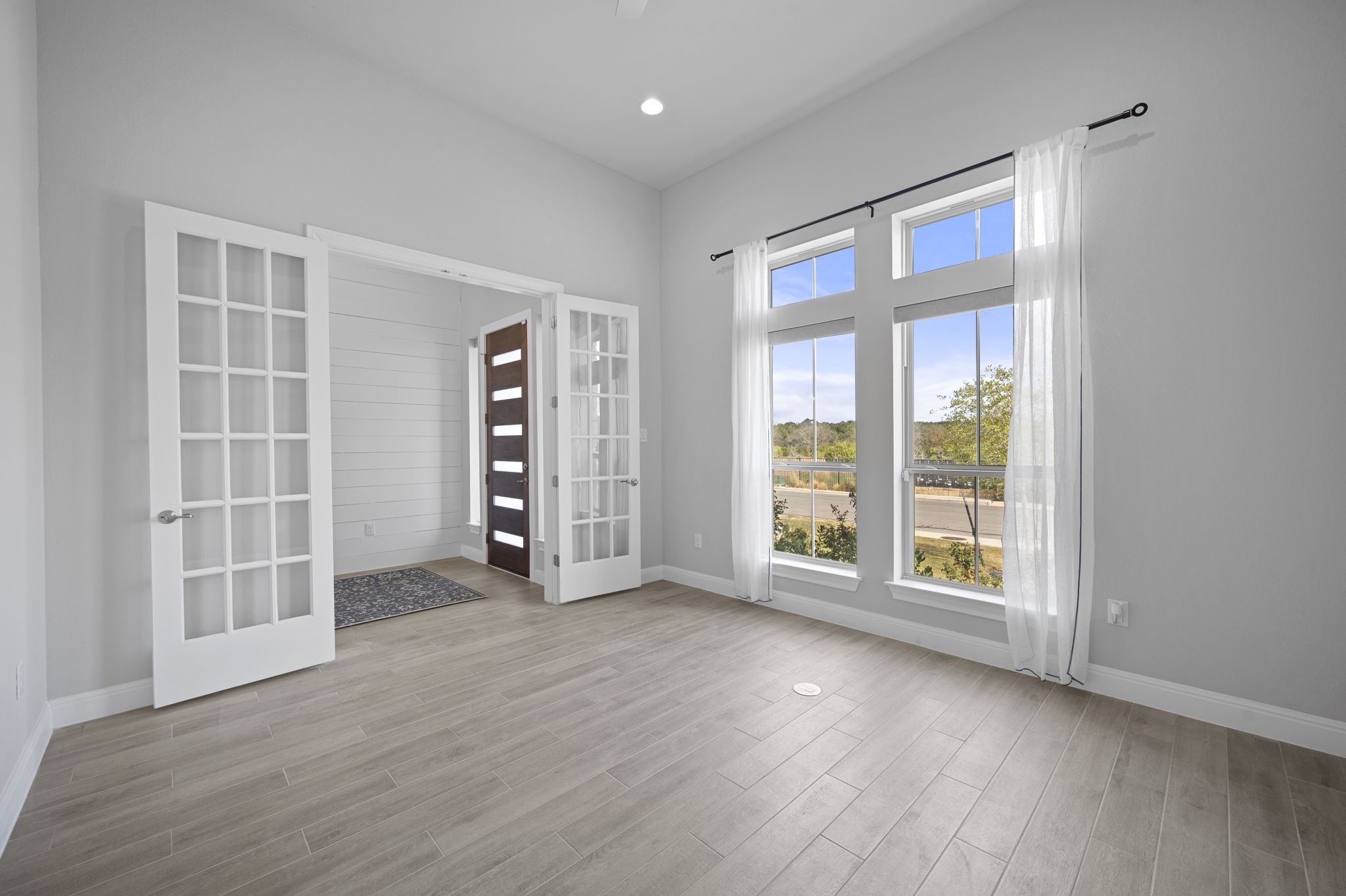 165 Eclipse Drive Austin, TX 78737 - Photo 6 of 38 an empty room with wooden floor and windows