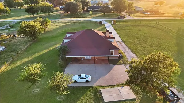 an aerial view of a house with a yard lake and outdoor seating