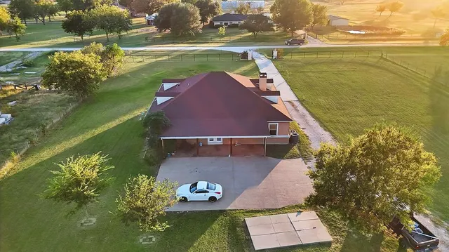 an aerial view of a house with a yard lake and outdoor seating