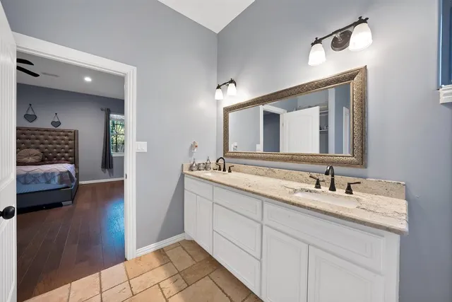 a en suite bathroom with a double vanity sink and a mirror