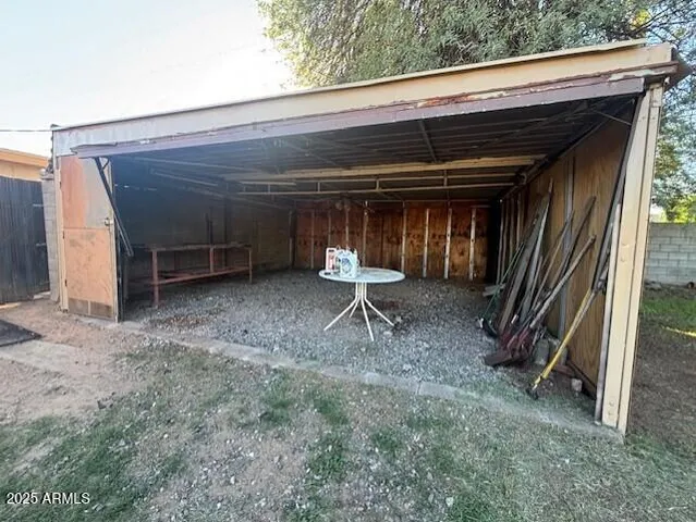 a view of a patio with table and chairs under an umbrella
