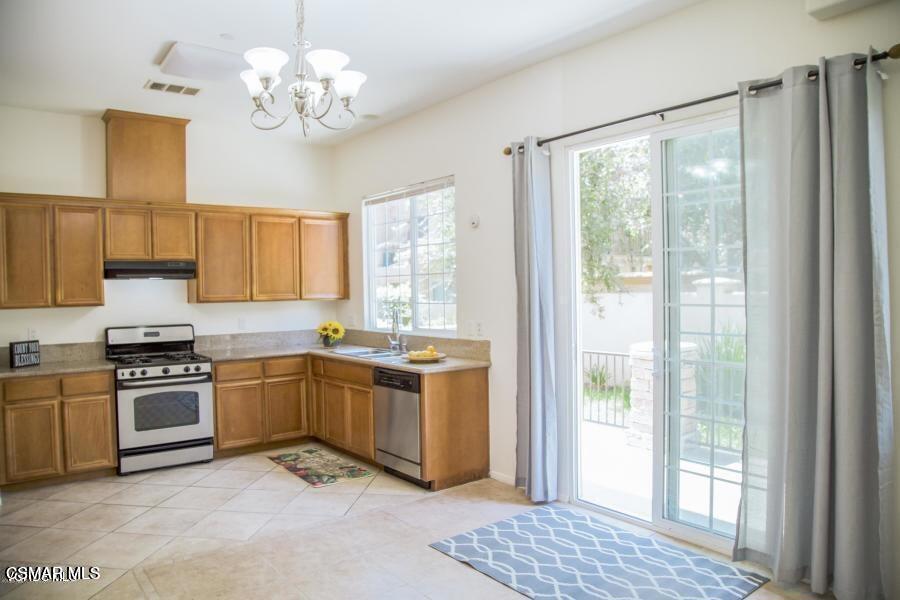 1484 Patricia Avenue, Unit 13 Simi Valley, CA 93065 - Photo 2 of 4 a kitchen with stainless steel appliances granite countertop a stove sink and refrigerator