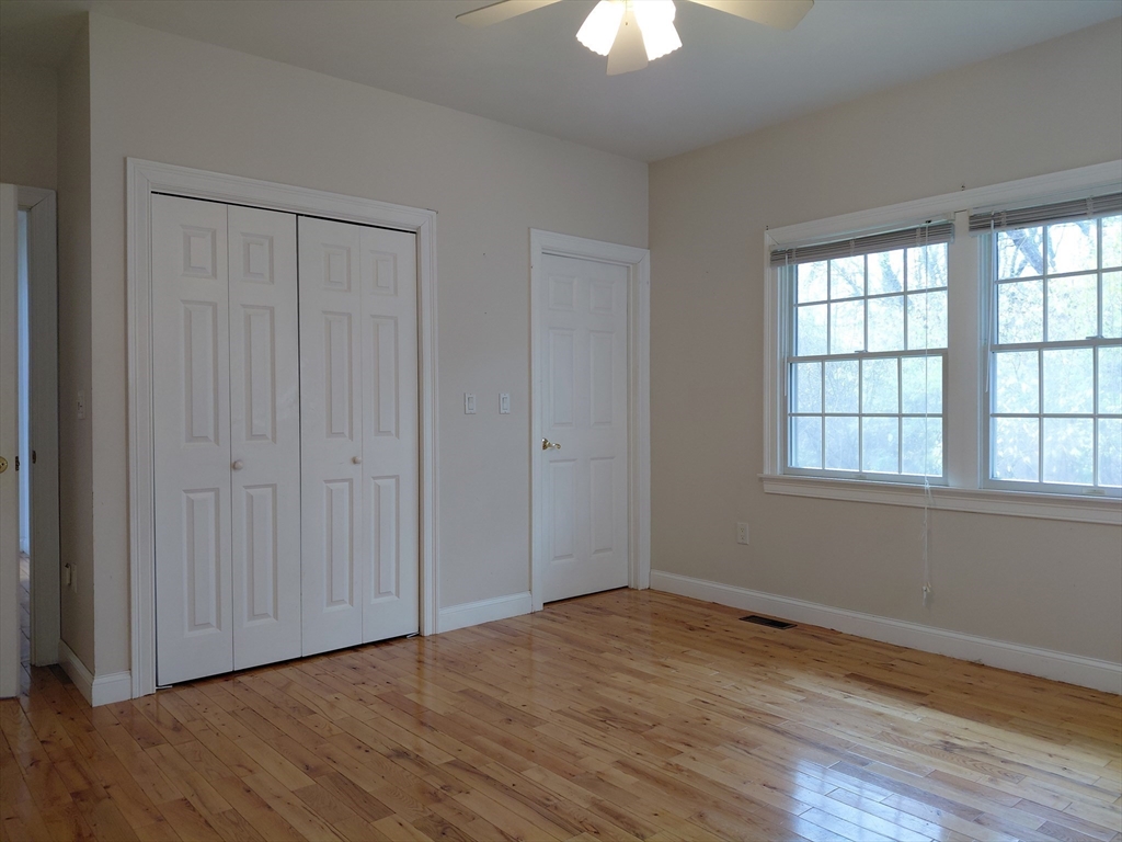 218 Lowell Street Lexington, MA 02420 - Photo 18 of 42 a view of an empty room with a window and wooden floor