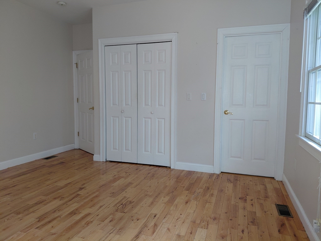218 Lowell Street Lexington, MA 02420 - Photo 19 of 42 a view of an empty room with wooden floor and a window