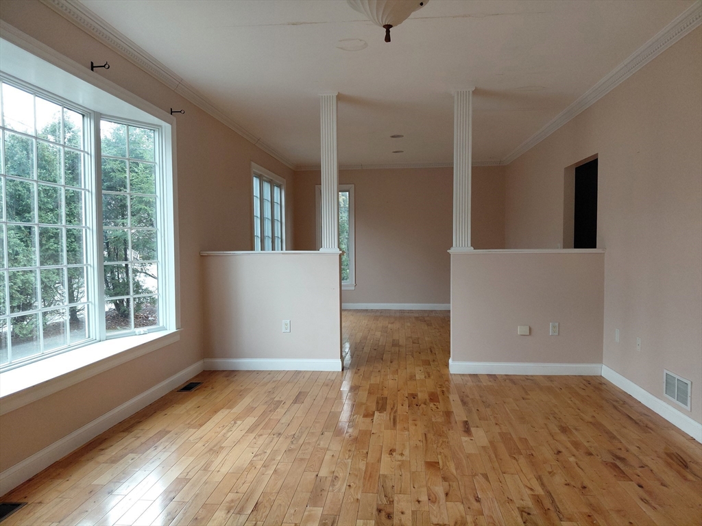 218 Lowell Street Lexington, MA 02420 - Photo 9 of 42 a view of an empty room with wooden floor and a window