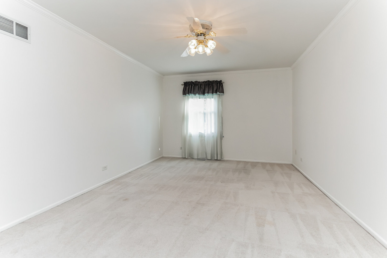 508 North Walnut Lane Schaumburg, IL 60107 - Photo 18 of 25 an empty room with a chandelier fan and windows