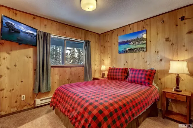 a bedroom with a bed and painting on the wall