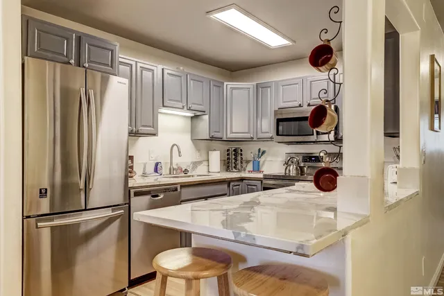 a kitchen with stainless steel appliances granite countertop a refrigerator sink and microwave