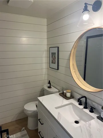 a bathroom with a sink a toilet and mirror