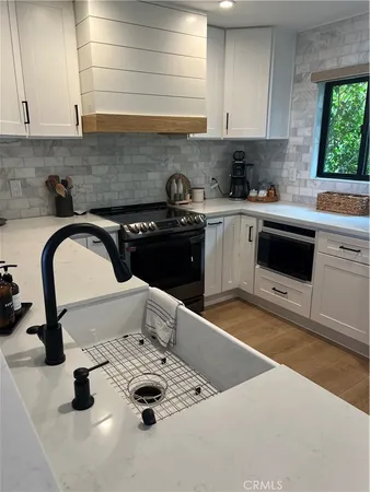 a kitchen with a sink a stove and cabinets