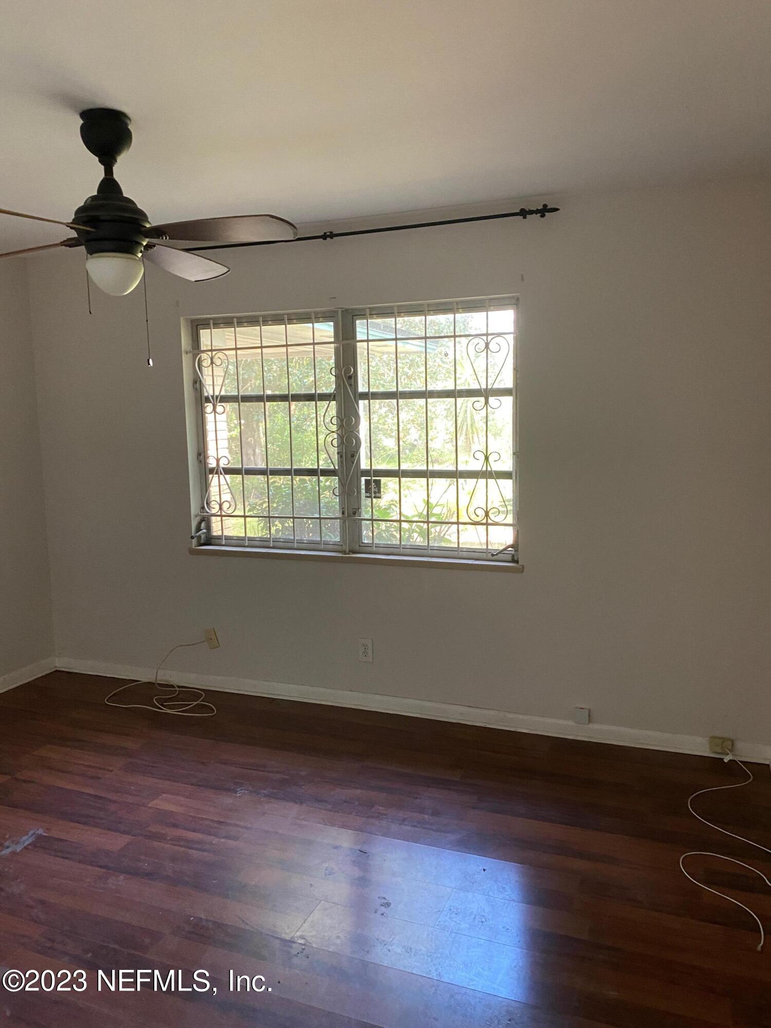 2827 Ribault Scenic Drive Jacksonville, FL 32208 - Photo 12 of 24 a view of an empty room with wooden floor and a window