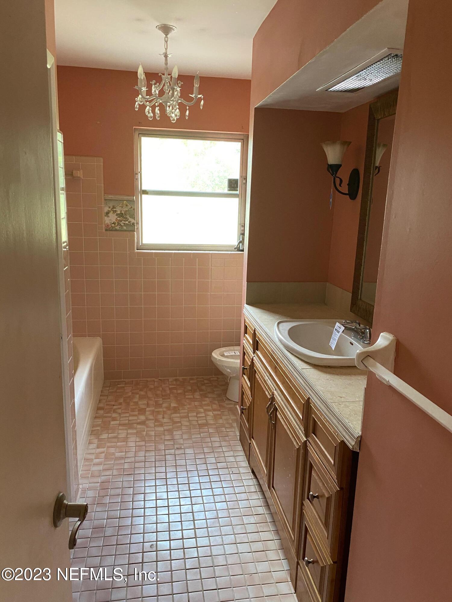 2827 Ribault Scenic Drive Jacksonville, FL 32208 - Photo 13 of 24 a bathroom with a sink a toilet and a mirror