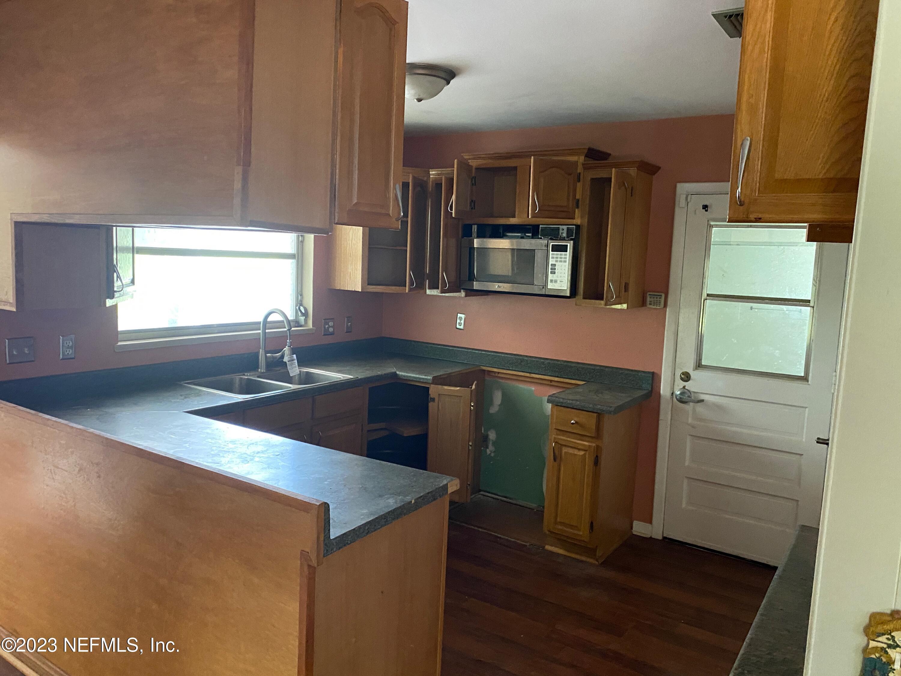 2827 Ribault Scenic Drive Jacksonville, FL 32208 - Photo 4 of 24 a kitchen with stainless steel appliances granite countertop a sink and a stove top oven