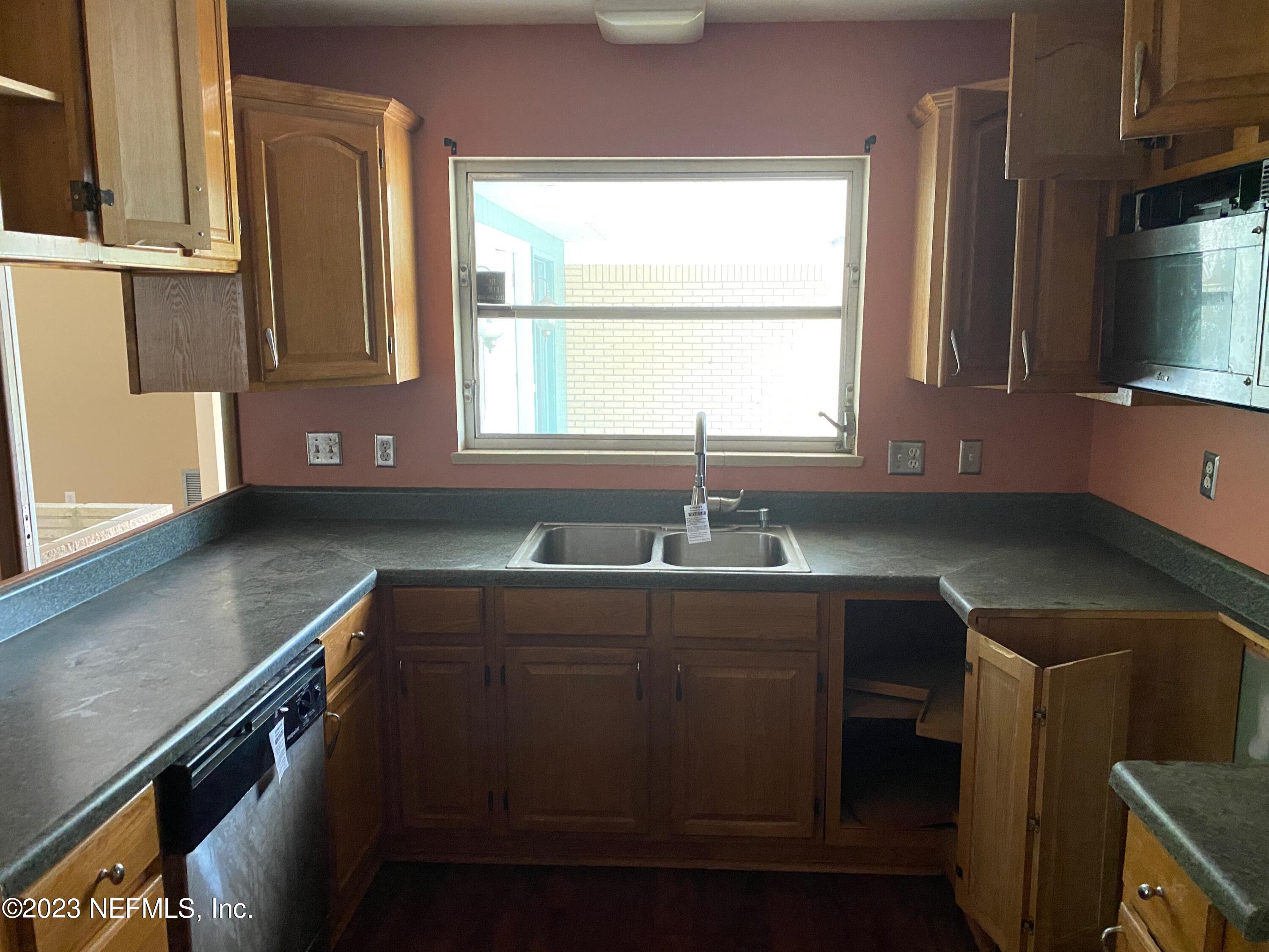 2827 Ribault Scenic Drive Jacksonville, FL 32208 - Photo 5 of 24 a kitchen with a sink cabinets and window
