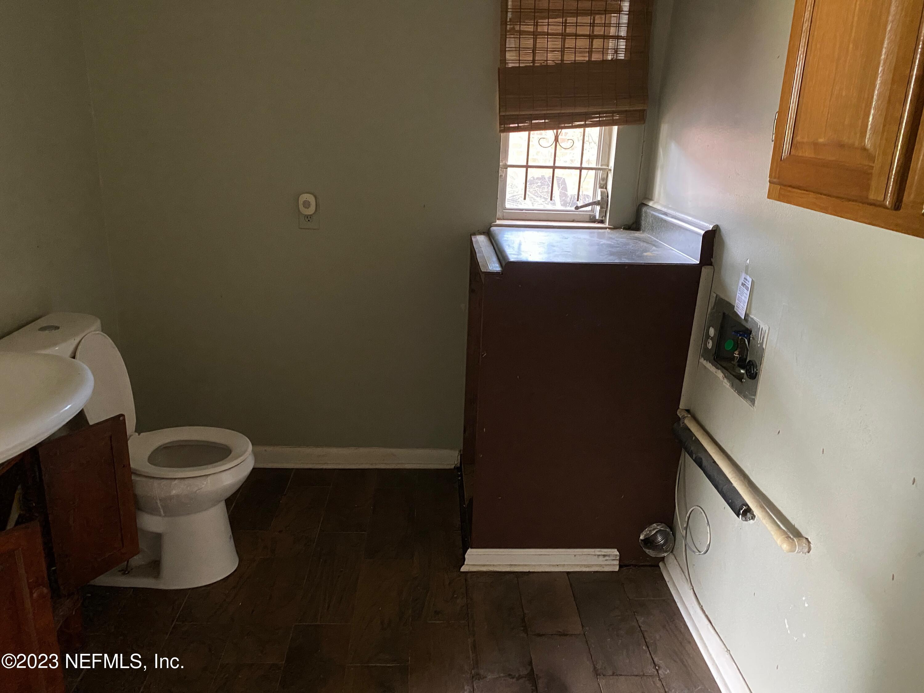 2827 Ribault Scenic Drive Jacksonville, FL 32208 - Photo 8 of 24 a bathroom with a toilet a sink and mirror