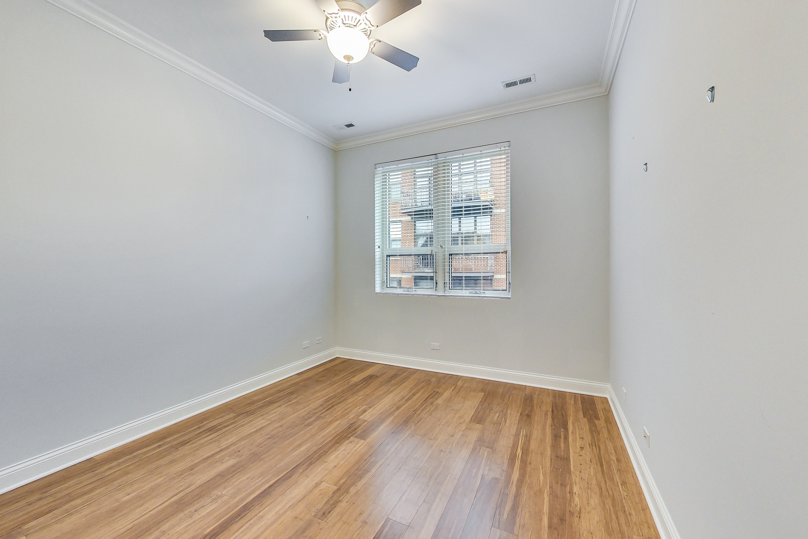 1247 West Madison Street, Unit 211 Chicago, IL 60607 - Photo 11 of 14 wooden floor in an empty room with a window