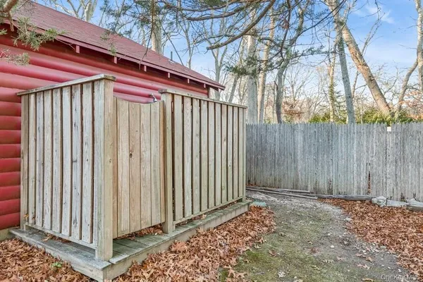 a view of a backyard with a small cabin and wooden fence