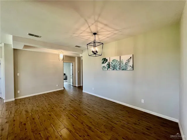 a view of a room with wooden floor ceiling fan and windows