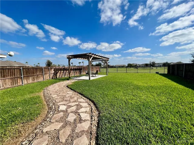 a view of a garden with a bench in the back yard