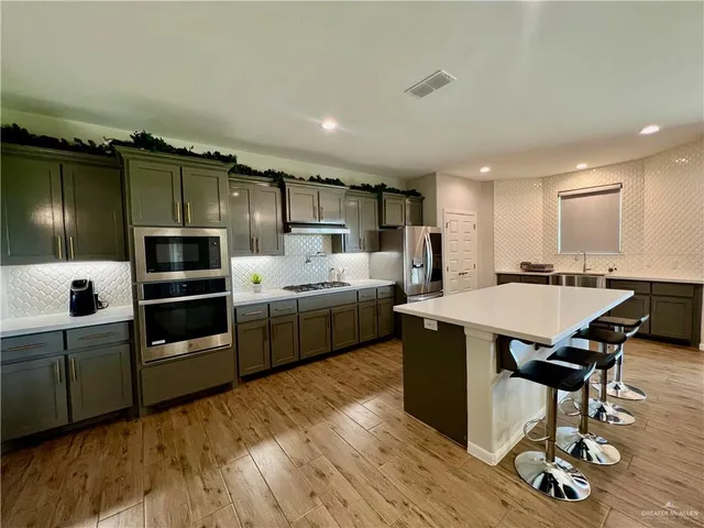 a kitchen with a table chairs refrigerator and microwave