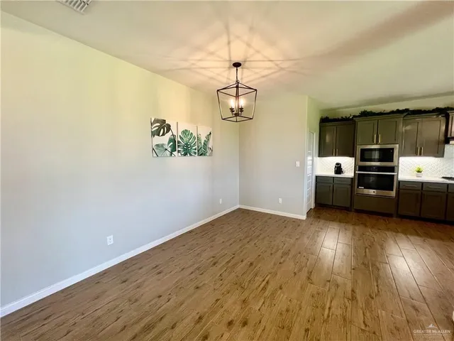 a view of a kitchen with a stove wooden floor and a refrigerator